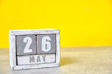 May 26 calendar made wooden cubes yellow background.With an empty space for your text.