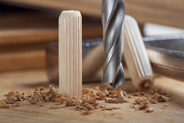 drill bit makes hole in wooden oak board for wooden dowel.