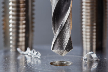 metal drill bit make holes in steel billet on industrial drilling machine. Metal work industry....
