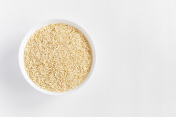 Basmati long rice in bowl on white background with copy space