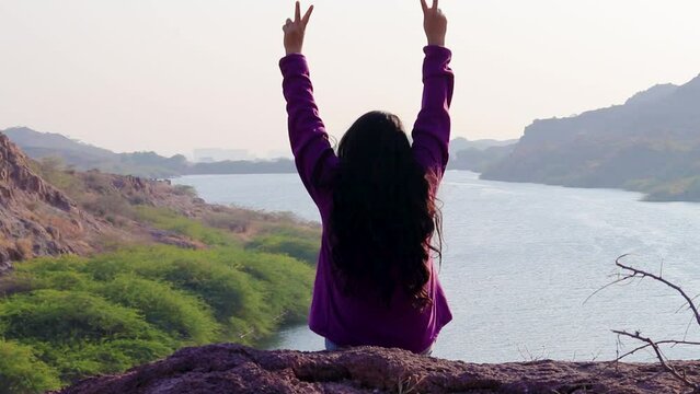 isolated young girl at mountain top with lake view backbit shot from flat angle