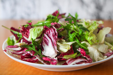 Fresh colorful salad served on a plate in a restaurant. Healthy and delicious food