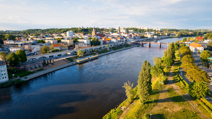 In Gorzów Wielkopolski, a drone photo was taken on a sunny day featuring the River Warta, the Cathedral, and the city center - obrazy, fototapety, plakaty