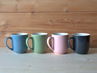 Cups of tea or coffee on a wooden background. Colorful cups on the buffet
