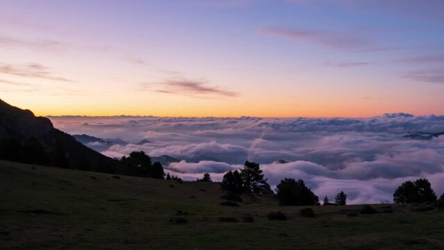 Coll de Pal, Bergued&agrave;, Girona, Spain. August 2022. Watch the breathtaking sunrise over the mountains as a sea of clouds ebbs and flows, creating a stunning splash-like effect against the peaks.