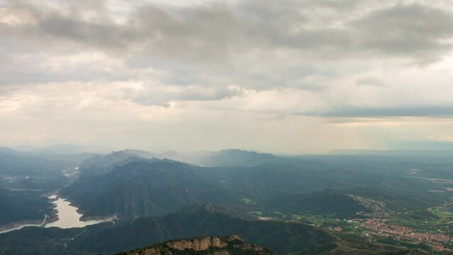 Berga, Catalunya, Spain. August 2022. Summer sunset at the viewpoint of La Baells reservoir: moving clouds create a spectacle of light and shadow among the mountains.