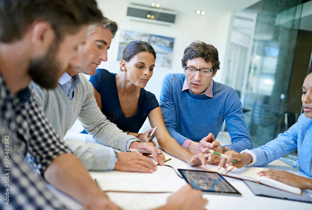 Poster putting their ideas on the table. a group of businesspeople discussing work using a digital tablet i