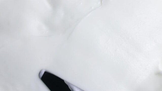 Top view of white smooth creamy smudged moisturizing face cream smears close up