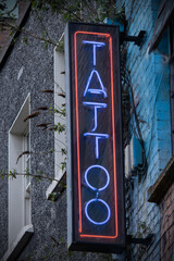 neon tattoo shop sign on side of building