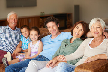 Carefree time as one big, happy family. a happy multi-generational family sitting together on a...