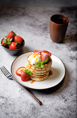 Sweet souffle pancakes decorated with fresh strawberries in a plate