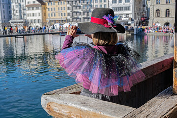 Frau in Fasnachtskostüm fotografiert auf der Kappelbrücke das Fasnachtsgeschehen, Luzern, Schweiz