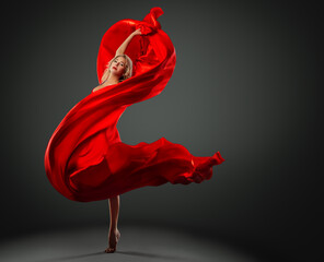 Ballerina dancing with Red Silk Fabric flying on Wind. Modern Ballet Dancer jumping over Dark...