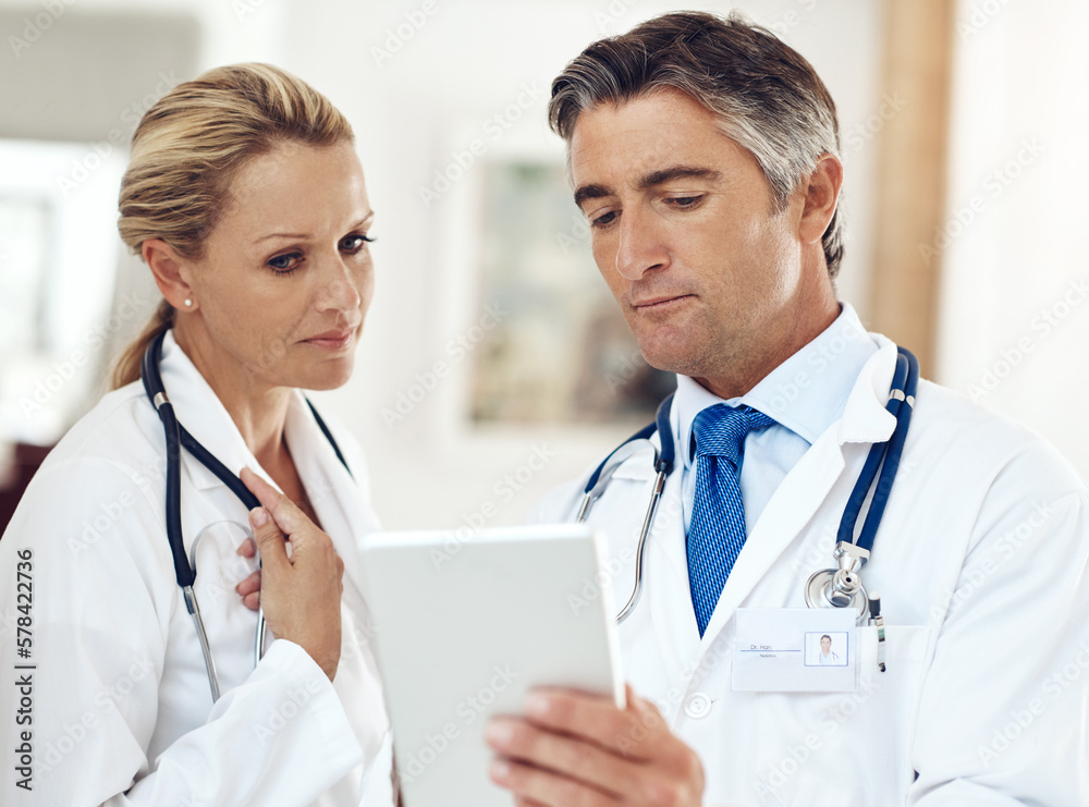 Poster Take a look at this...two doctors talking together over a digital tablet in the hospital.