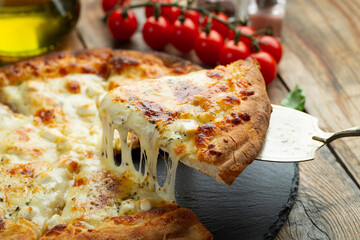 A slice of hot Italian pizza with stretching cheese. Pizza four cheeses with basil. - obrazy, fototapety, plakaty