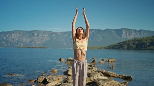 Portrait woman doing morning yoga session process meditation practice, sun salutation and breathing exercises with mountains landscape