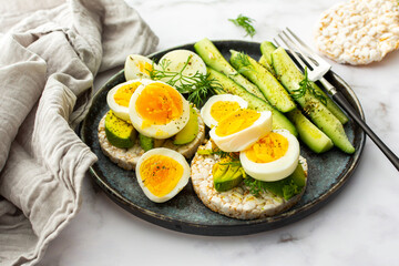 Healthy breakfasts, rice cakes with avocado and boiled eggs with dill and cucumber with spices, healthy wholesome food