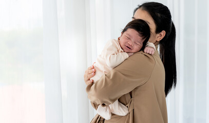 Portrait images of half Nigerian half Thai, 1-month-old baby newborn girl, sleeping with her mother being held, to family and infant newborn concept.