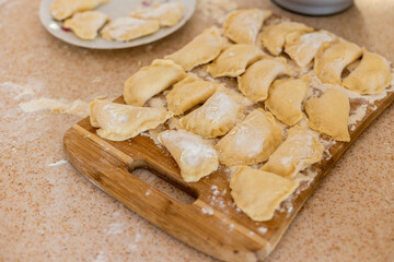 Fototapeta na wymiar Raw dumpling. Preparation dumplings on a wooden board.