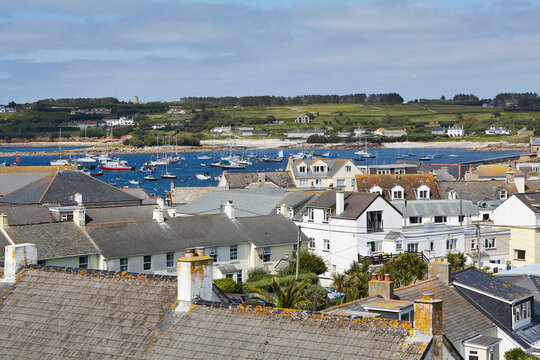 Isles of Scilly, United Kingdom -  view over the roofs of Hugh Town with sailboats anchoring in harbor in the background