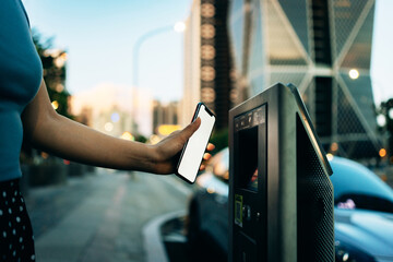 Business woman paying for parking using mobile phone