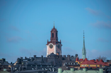 From south, the tower of the renovated church Stor Kyrkan, roofs and facades in the old town Gamla Stan, a sunny spring day in Stockholm