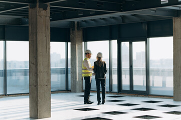 Fototapeta na wymiar two architect engineers are walking in a constructed office building. implementation of the project