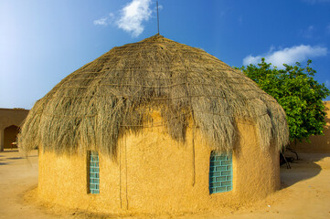 Thatched roof mud house in the desert