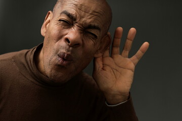 suffering from deafness and hearing loss on grey background with people stock photo