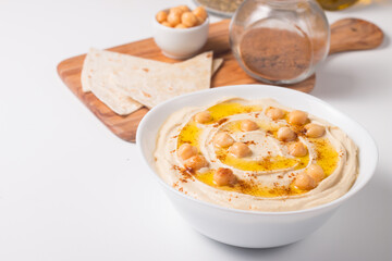 Hummus in a plate with chickpeas, smoked paprika, olive oil and pita. Vegetarian food.