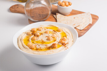 Hummus in a plate with chickpeas, smoked paprika, olive oil and pita. Vegetarian food.