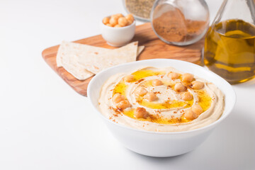 Hummus in a plate with chickpeas, smoked paprika, olive oil and pita. Vegetarian food.