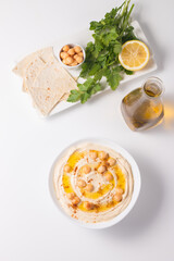 Hummus in a plate with chickpeas, smoked paprika, olive oil and pita. Vegetarian food.