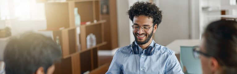 Group of smiling coworkers working together analyzing the charts in modern office
