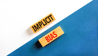 Implicit bias symbol. Concept words Implicit bias on wooden block. Beautiful white and blue table...