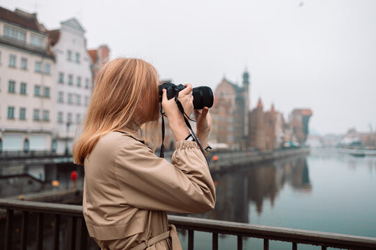 Traveler, travel Caucasian young woman or girl use camera take photo, old town street, city tourism. Holiday trip or vacation, hobby concept. 