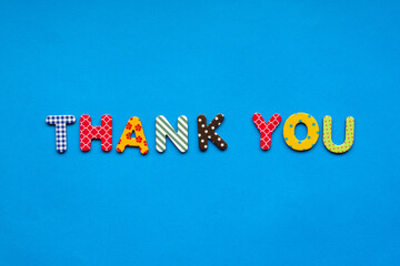 text thank you from bright colored paper letters on blue paper background