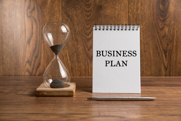 Hourglass and inscription business plan on notepad