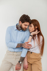 Fashion beautiful couple, stylish redhead woman model and handsome hipster man in stylish elegant clothes with shirt in studio on white background