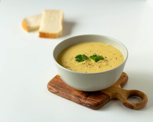 Pumpkin soup with parsley in a bowl on a wooden board