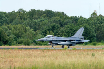 Fototapeta na wymiar Military F16 fighter jet taxiing after landing in the Netherlands. Netherlands Air Force F16 fighter jet aircraft 