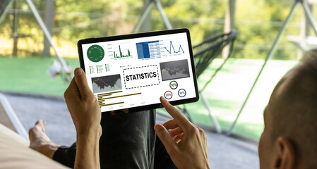 Laptop Computer Showing Statistical Infographics Stands on a Desk in the Living Room. In the Background Cozy Living Room.
