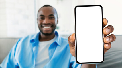 Smiling Black Man Showing Smartphone With Big Blank White Screen At Camera