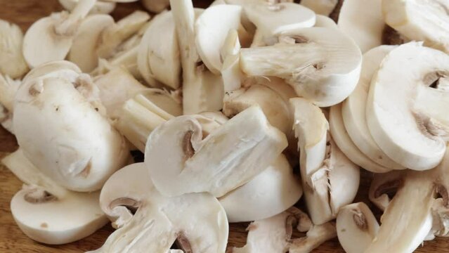 morceaux de champignons de Paris en gros plan, sur une table en bois