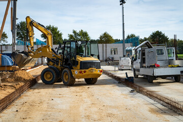Baubranche - kleiner Bagger erledigt Erdaushebungen auf einer Baustelle.