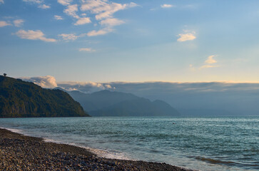 sunset on the beach with mountains in the background