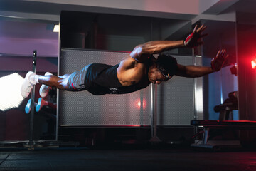 20s black male doing flying push ups in a gym. - obrazy, fototapety, plakaty