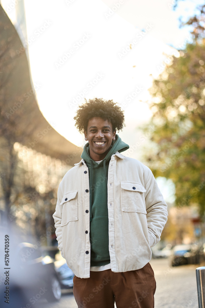 Sticker stylish smiling positive young african american guy model standing at big city street. happy ethnic 