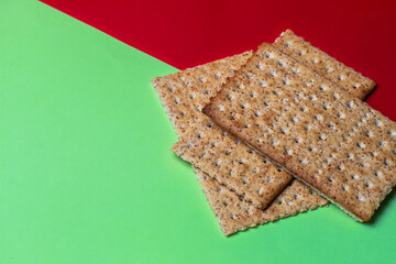 biscoito salgado crocante de trigo com fundo verde e vermelho
