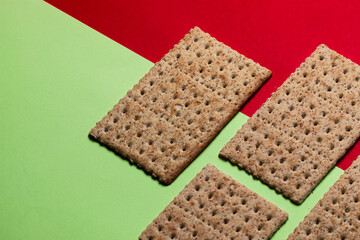 biscoito salgado crocante de trigo com fundo verde e vermelho